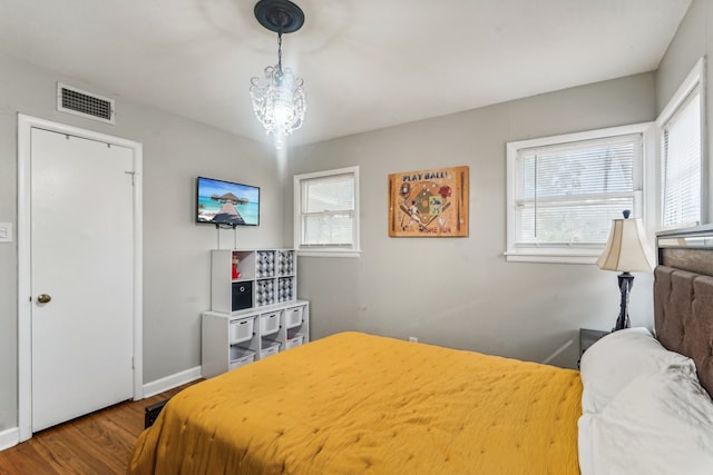 bedroom featuring hardwood / wood-style flooring and an inviting chandelier