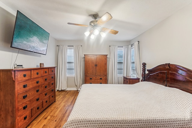 bedroom featuring multiple windows, light wood-type flooring, and ceiling fan