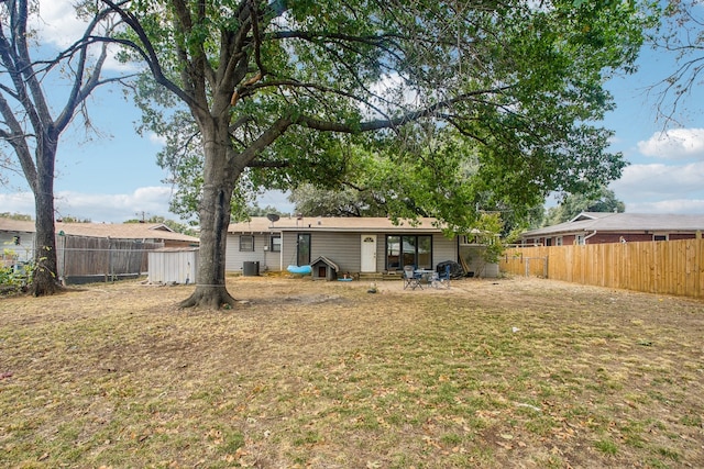 back of property with a storage shed, a yard, and a patio area