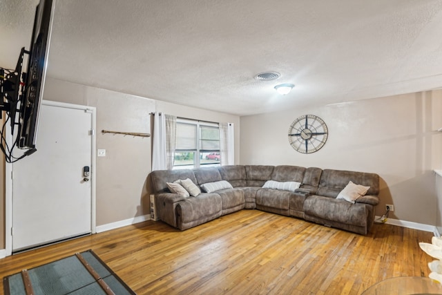 living room with hardwood / wood-style flooring and a textured ceiling