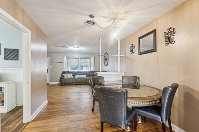 dining area with an inviting chandelier and wood-type flooring