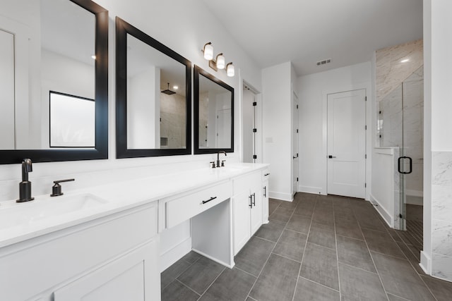 bathroom featuring vanity, a shower with shower door, and tile patterned flooring