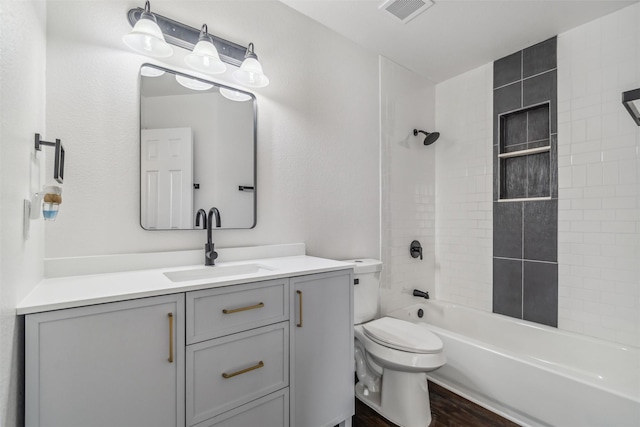 full bathroom with vanity, tiled shower / bath combo, toilet, and hardwood / wood-style flooring