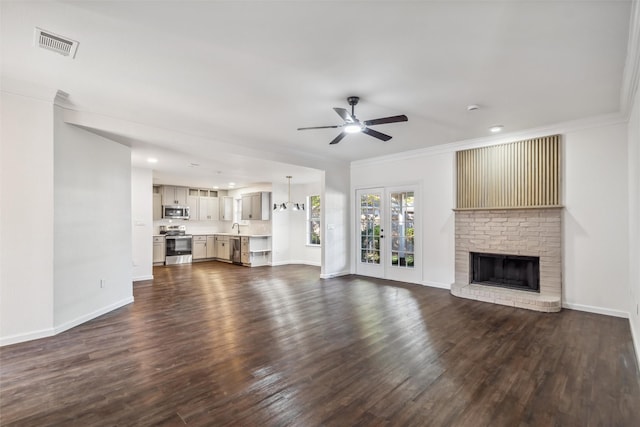 unfurnished living room featuring ornamental molding, dark hardwood / wood-style floors, ceiling fan, and a fireplace