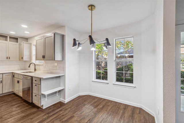 kitchen with sink, a notable chandelier, decorative backsplash, dark hardwood / wood-style flooring, and decorative light fixtures