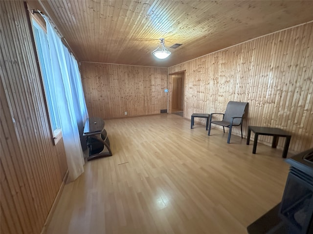 unfurnished room featuring light hardwood / wood-style floors, wood ceiling, and wooden walls