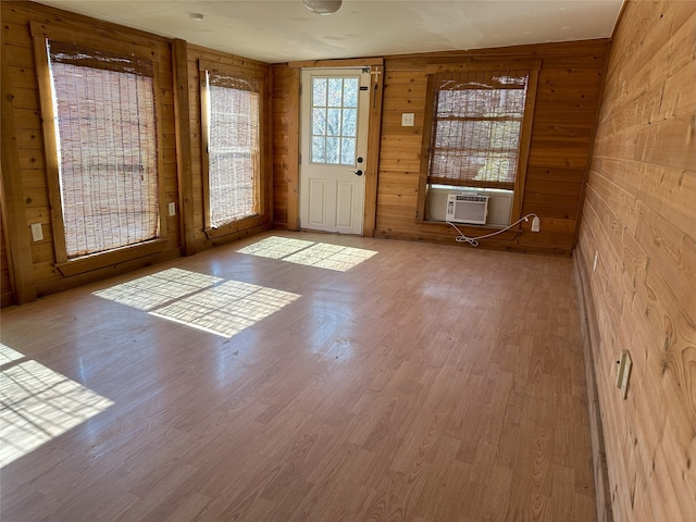 interior space with wood walls, hardwood / wood-style floors, and cooling unit