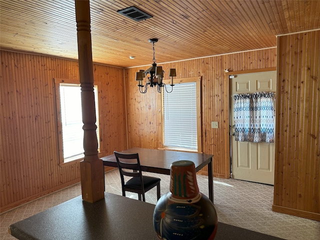 dining area featuring carpet, wood walls, wooden ceiling, and an inviting chandelier