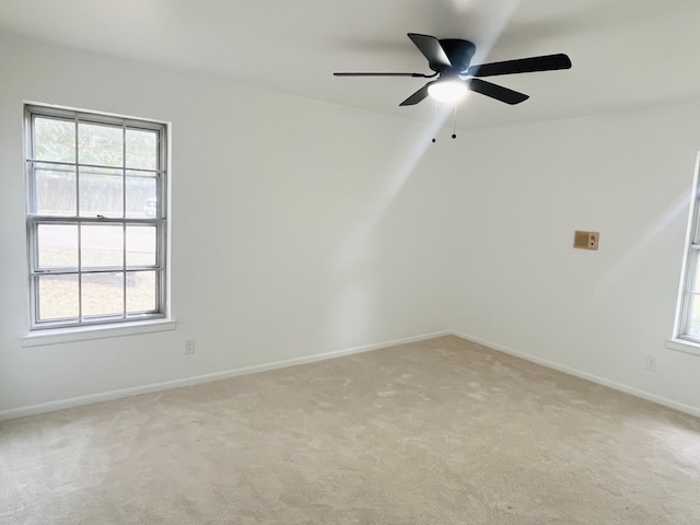 unfurnished room with light colored carpet and ceiling fan