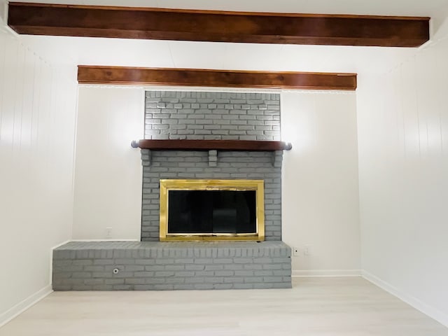 details with beam ceiling, wood-type flooring, and a brick fireplace