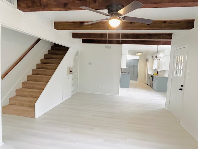 interior space with beam ceiling, hardwood / wood-style flooring, and ceiling fan with notable chandelier