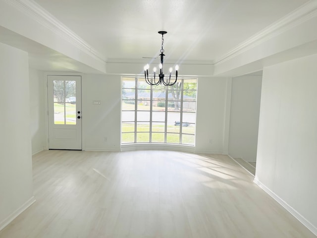 unfurnished dining area with ornamental molding, an inviting chandelier, and light wood-type flooring