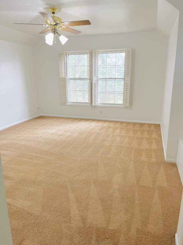 empty room featuring ceiling fan and light colored carpet