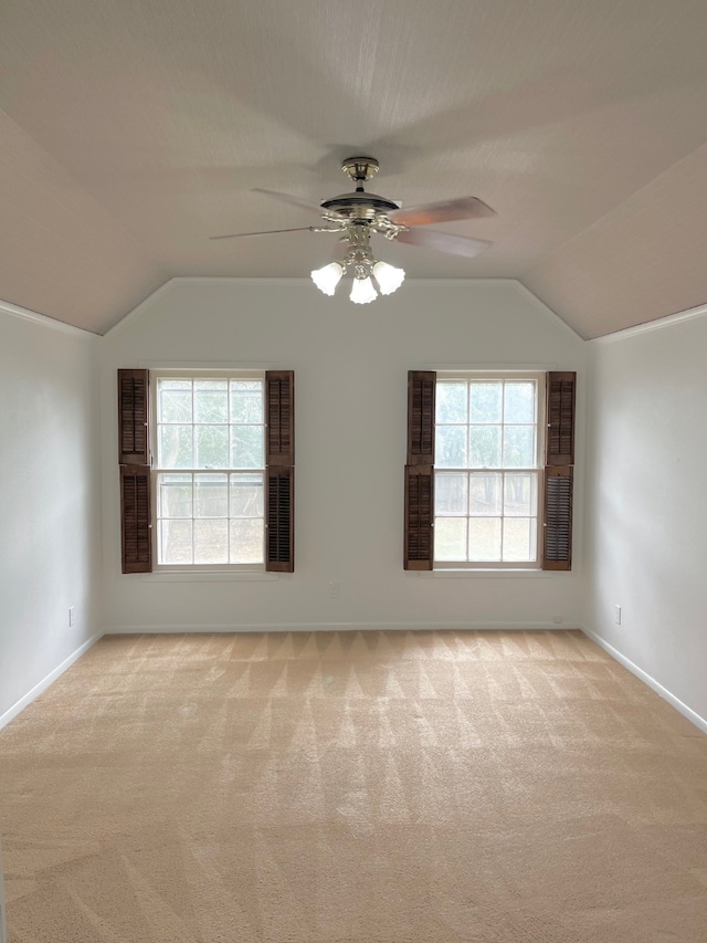 carpeted empty room featuring vaulted ceiling, a wealth of natural light, and ceiling fan