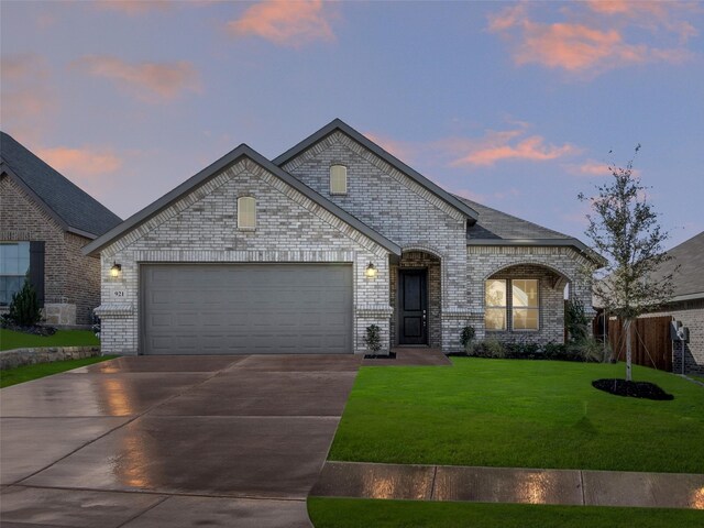 french country inspired facade featuring a yard and a garage