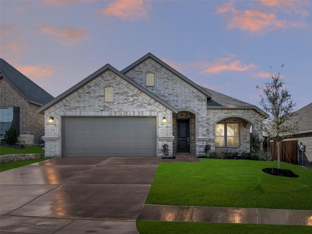 french country home with a garage and a yard