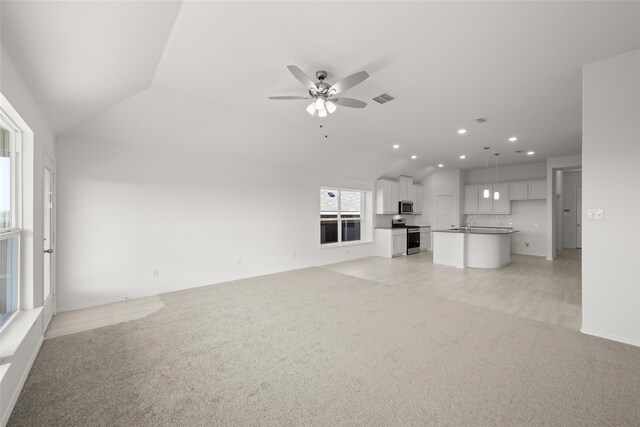 kitchen featuring white cabinets, stainless steel appliances, lofted ceiling, and sink