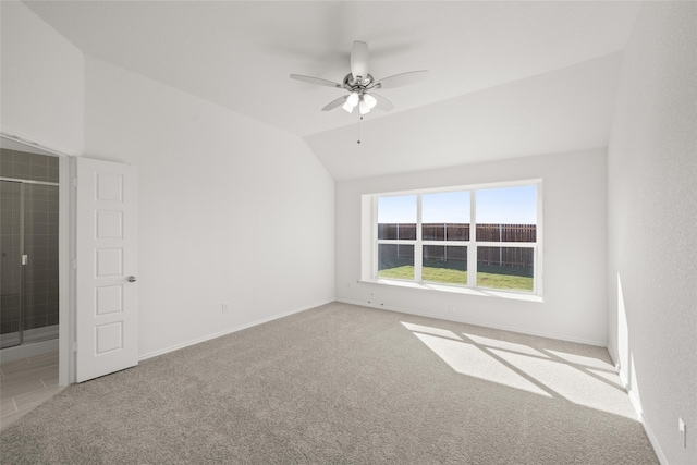 unfurnished room featuring light carpet, vaulted ceiling, and ceiling fan