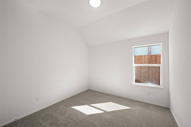 unfurnished room with carpet and vaulted ceiling