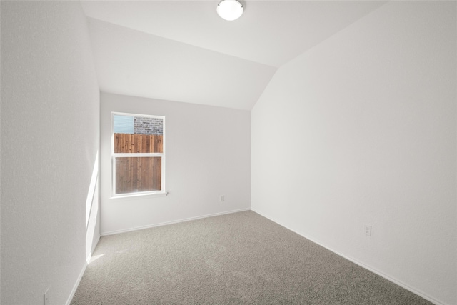 carpeted spare room with lofted ceiling