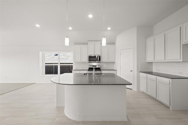 kitchen with sink, hanging light fixtures, stainless steel appliances, a kitchen island with sink, and white cabinets