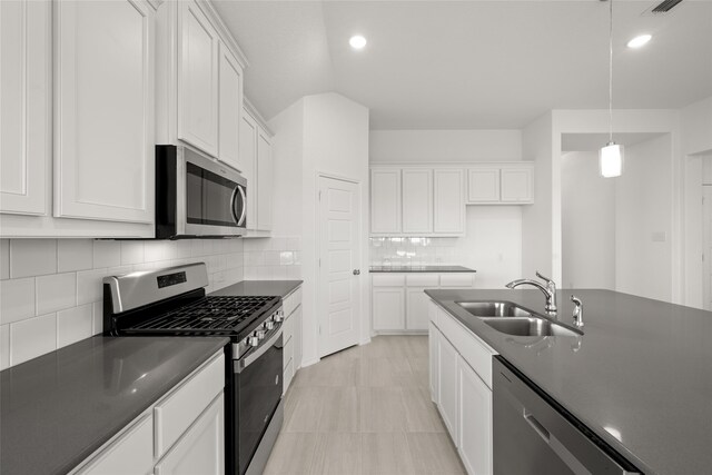 kitchen with sink, stainless steel appliances, backsplash, decorative light fixtures, and white cabinets