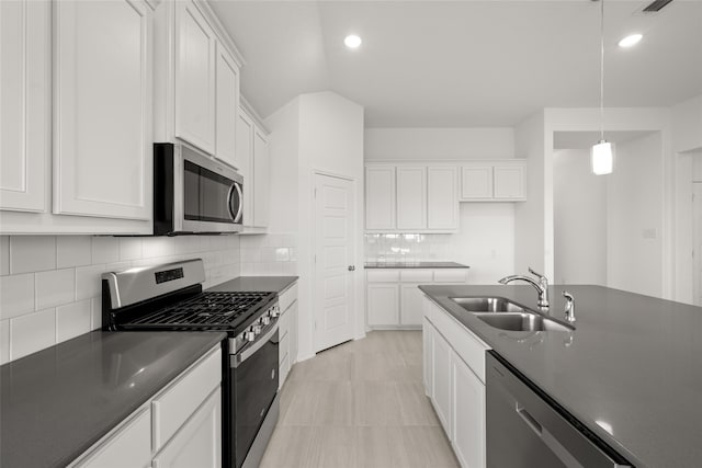 kitchen with white cabinetry, decorative light fixtures, sink, appliances with stainless steel finishes, and decorative backsplash