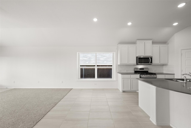 kitchen featuring sink, backsplash, white cabinets, and stainless steel appliances