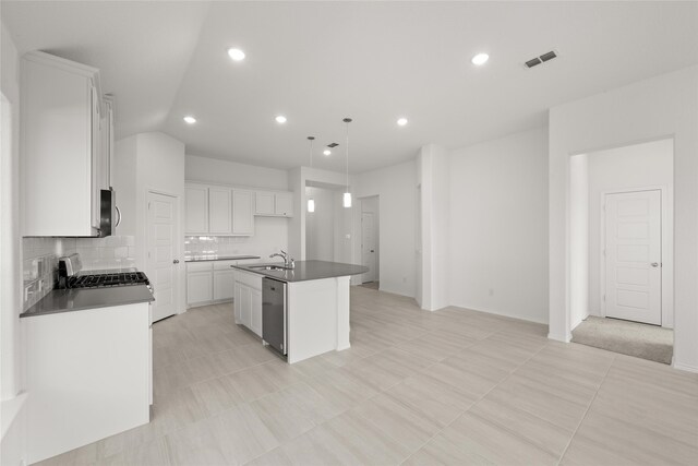 kitchen featuring stainless steel appliances, sink, decorative light fixtures, white cabinetry, and an island with sink