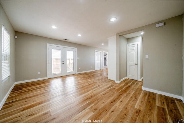 unfurnished living room featuring french doors and light hardwood / wood-style flooring