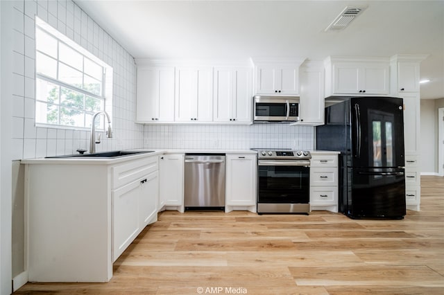 kitchen featuring white cabinetry, light hardwood / wood-style flooring, appliances with stainless steel finishes, and sink