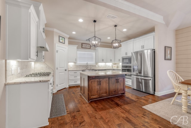 kitchen with a center island, white cabinets, dark hardwood / wood-style floors, light stone counters, and stainless steel appliances