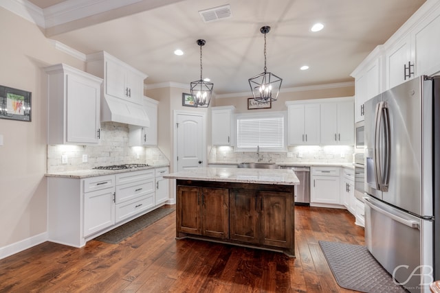 kitchen with white cabinetry, a kitchen island, stainless steel appliances, and dark hardwood / wood-style floors