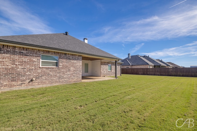 back of property with a patio area and a yard