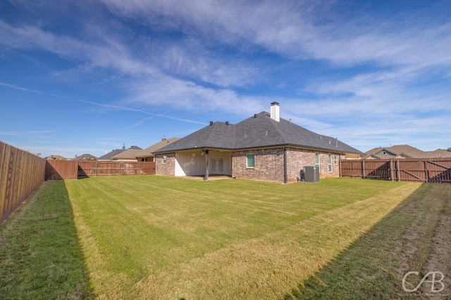 back of house with a lawn, ceiling fan, and cooling unit