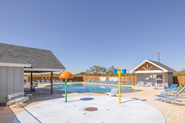 view of pool with a patio area and an outbuilding