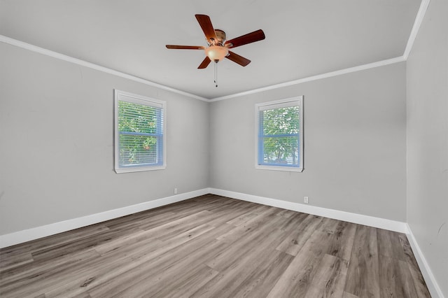 spare room featuring light hardwood / wood-style flooring, a healthy amount of sunlight, and crown molding