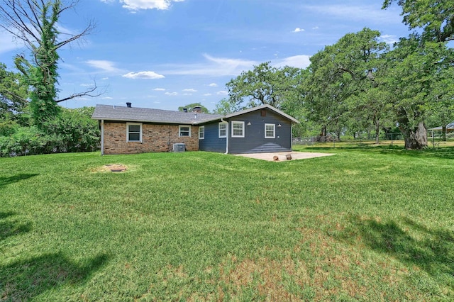 back of property with a lawn and a patio