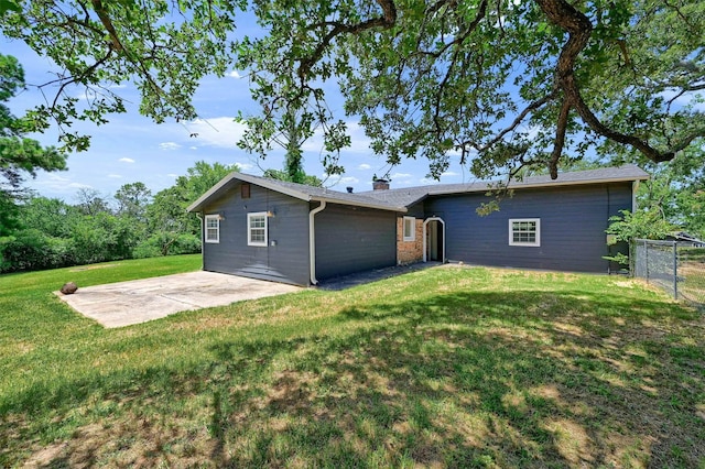 back of property featuring a patio area and a lawn