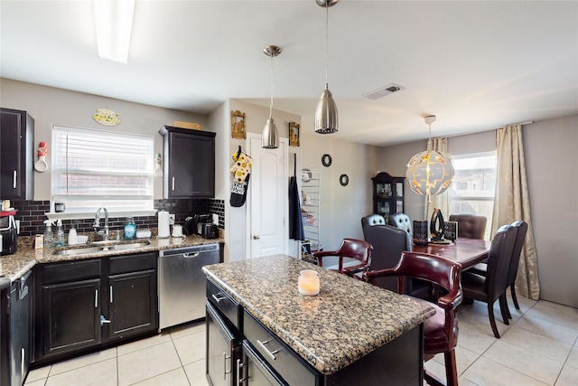 kitchen with a healthy amount of sunlight, sink, a kitchen island, and dishwasher