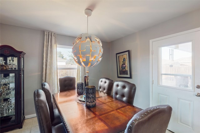 tiled dining room with a chandelier