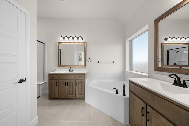 bathroom featuring independent shower and bath, vanity, lofted ceiling, and tile patterned floors