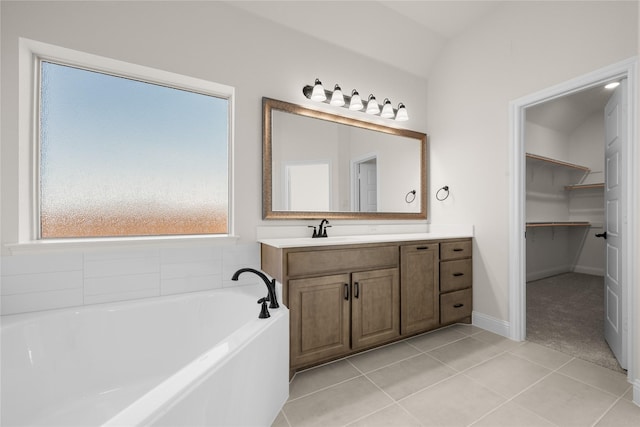 bathroom with tile patterned flooring, a tub to relax in, and vanity