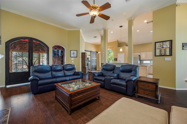 living room with dark wood-type flooring, crown molding, a barn door, and ceiling fan