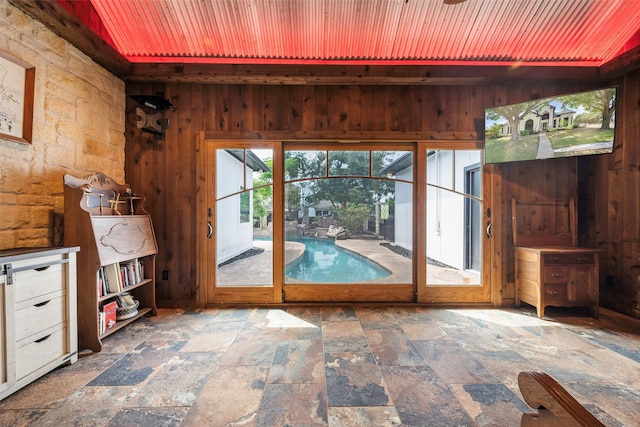 doorway to outside featuring wood walls