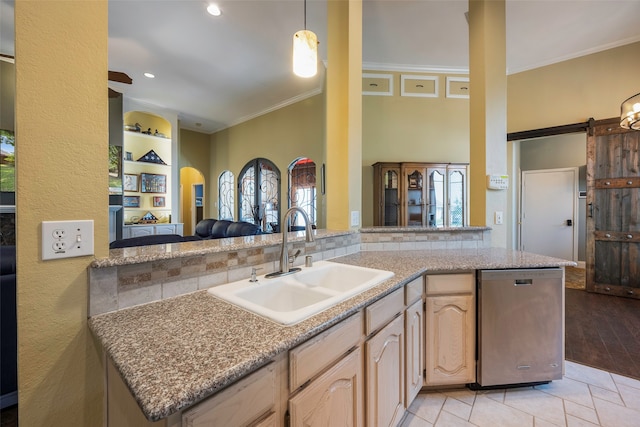 kitchen featuring light wood-type flooring, sink, kitchen peninsula, and a barn door