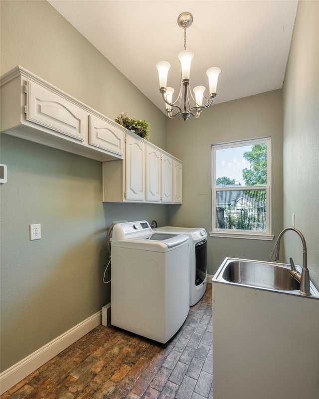 laundry area with sink, washer and clothes dryer, an inviting chandelier, cabinets, and dark hardwood / wood-style floors