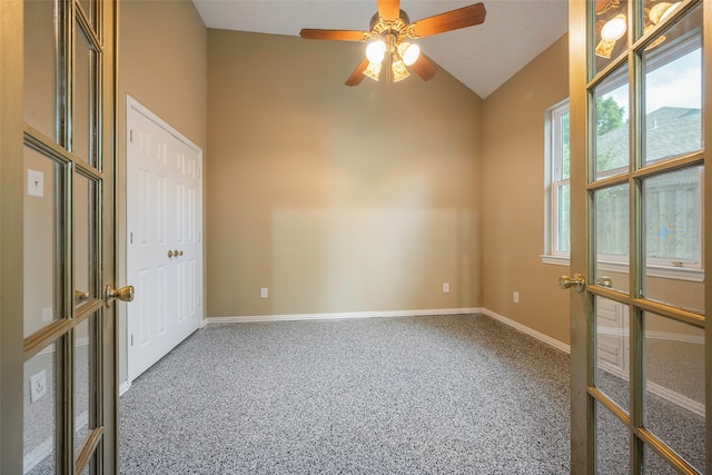 carpeted spare room featuring lofted ceiling and ceiling fan