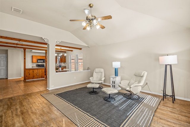 sitting room featuring light hardwood / wood-style flooring, ceiling fan, and vaulted ceiling with beams