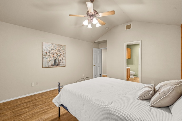 bedroom featuring hardwood / wood-style floors, ensuite bath, lofted ceiling, and ceiling fan